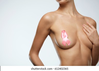 Health Care. Closeup Of Beautiful Woman's Perfect Body With Breast Cancer Awareness Ribbon On Nipple. Young Sexy Topless Woman With Hand On Her Breast. Beauty Concept. High Resolution