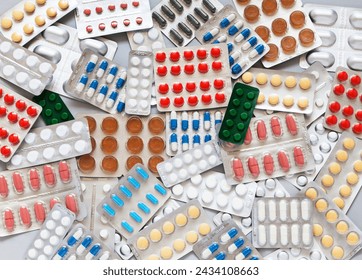 Health care concept. Checking medicine cabinet pills for expired medicines. Expiration date is indicated on packages of medicines. Pile of pills on table. Medicines background. Flat lay, close-up - Powered by Shutterstock