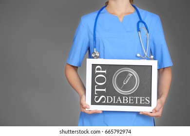 Health care concept. Doctor holding small chalkboard with text STOP DIABETES on gray background - Powered by Shutterstock