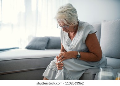 Health Care Concept. Woman Suffering From Pain In Knee, Closeup. Old Age, Health Problem And People Concept - Senior Woman Suffering From Pain In Leg At Home