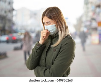 Health care concept. Young woman in face mask on city street - Shutterstock ID 649968268
