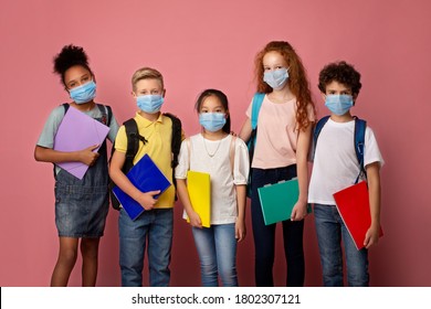Health care and education concept. Portrait of schoolchildren wearing protective masks against pink background - Powered by Shutterstock