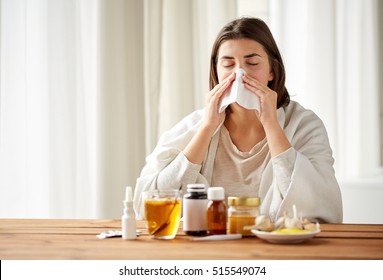 health care, flu, hygiene, age and people concept - sick woman with medicine blowing nose to paper wipe at home - Shutterstock ID 515549074