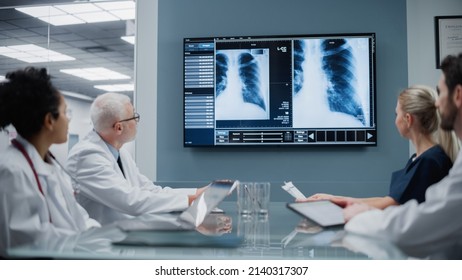 Health Care Hospital Conference Meeting Room With Diverse Team Of Medical Doctors. Scientists Talk, Discuss X-Ray Shown On TV Screen. Medical Experts Develop New Drugs, Medicine, Treatment Method