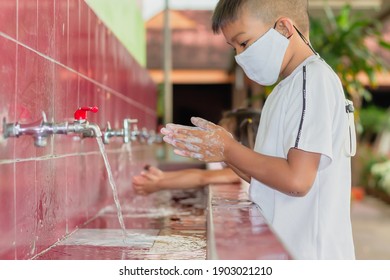 Health Care And Kid Concept. Asian Child Boy Washing His Hands Before Eating Food And After Play The Toys At The Washing Bowl. A Boy Aged Of 6-7 Years Old. He Wearing A Face Mask. Corona Virus.