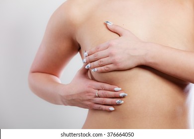 Health care medical concept. Close up young woman examining her breasts for lumps or signs of breast cancer
