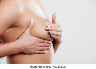 Health care medical concept. Close up young woman examining her breasts for lumps or signs of breast cancer