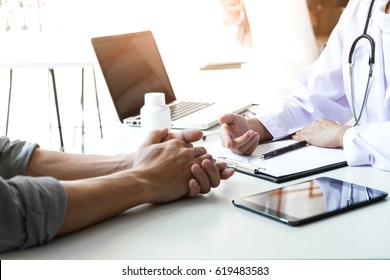 Health care and Medical concept, Doctor and patient are discussing something, just hands at the table. - Shutterstock ID 619483583