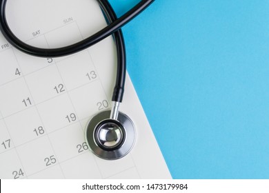 Health Care And Medical Exam Schedule Calendar, Reminder Or Appointment Concept, Doctor's Stethoscope On White Clean Calendar With Date On Blue Background With Copy Space.