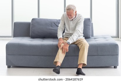 Health care and problem concept  Uhappy senior man suffering from knee ache at home. Knee joint injury. Gout. Rheumatoid. Arthritis. Osteoporosis - Shutterstock ID 2064187619