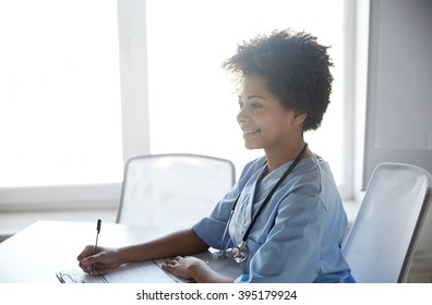 health care, profession, people and medicine concept - happy female doctor or nurse with clipboard and pen writing at hospital - Shutterstock ID 395179924