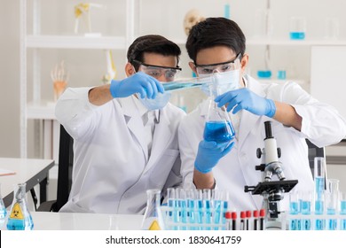 Health care researchers working in life science laboratory. Male research scientist and supervisor preparing and analyzing microscope slides in research lab. Invention of the coronavirus vaccine - Powered by Shutterstock - Get 15% off with code: PIKWIZARD15