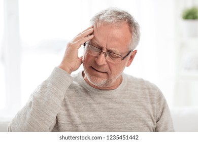 Health Care, Stress, Old Age And People Concept - Senior Man Suffering From Headache At Home