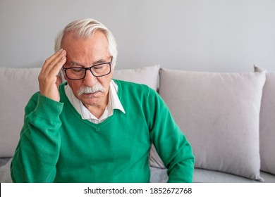 Health care, stress, old age and people concept - Senior man suffering from headache at home. Old man suffering from headache. A Distraught Senior Man Suffering From a Migraine