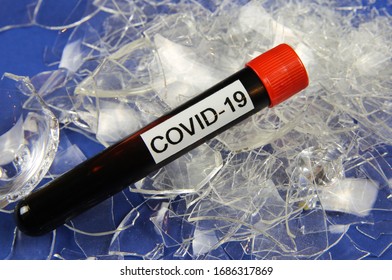 Health Care System Collapse And Economic Crisis Shutdown Concept: Isolated Blood Sample Vial With Word Covid-19 On Pile Broken Shattered Glass Shards (focus On Vial)