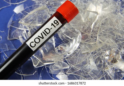 Health Care System Collapse And Economic Crisis Concept: Isolated Blood Sample Vial With Word Covid-19 On Pile Broken Shattered Glass Shards (focus On Vial)