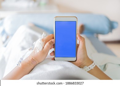 Konzept der Gesundheitstechnologie, Bluescreen-Mock-up Smartphone für Text, Hospital-Patientin Seniorinnen mit Smartphone beim Einholen der Augenweidensaline, iV-Tropfen, intravenöse Nadel im Krankenhaus