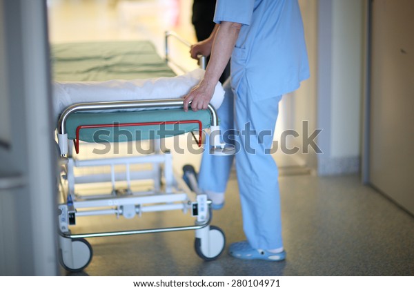 Health care\
worker pushing hospital mobile\
bed