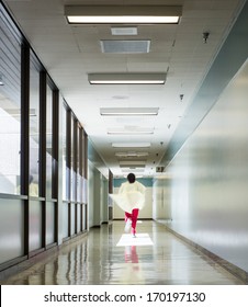 Health care worker running down a hospital corridor