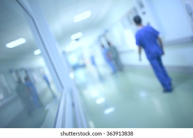 Health Care Worker Walking Down The Hall Of The Hospital, Defocused.