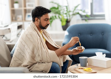 Health, Cold And People Concept - Sick Young Indian Man In Blanket Drinking Hot Tea With Lemon, Honey And Ginger At Home