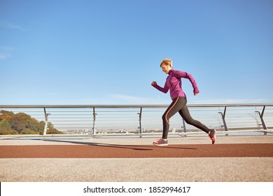 Health Comes First. Full Length Shot Of Motivated Active Mature Woman In Sportswear Running Outdoors On A Sunny Day. Side View