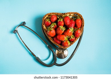 Health concept. Fresh strawberries with stethoscope in blue background , top view. - Powered by Shutterstock