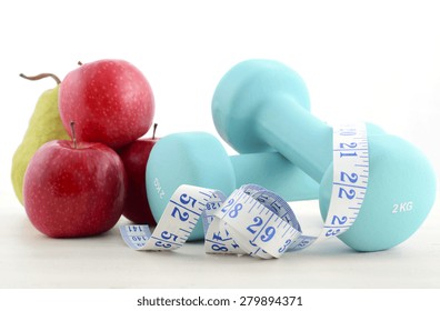 Health And Fitness Concept With Blue Dumbbells, Tape Measure And  Fresh Fruit On White Distressed Wood Table Background.