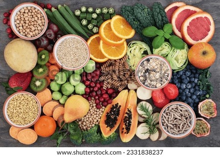 Health food concept for a high fiber diet with fruit, vegetables, cereals, whole wheat pasta, grains, legumes and herbs. Foods high in anthocyanins, antioxidants, smart carbohydrates and vitamins on m