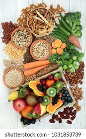 Health food for a high fibre diet with whole wheat pasta, grains, legumes, nuts, fruit, vegetables and cereals with foods high in omega 3,  antioxidants and vitamins. Rustic background top view.