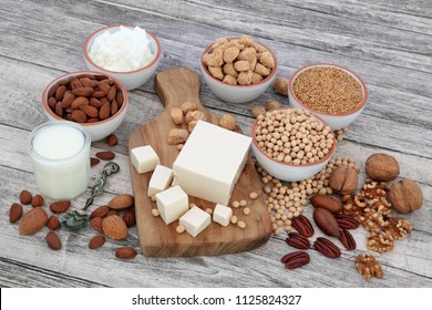 Health Food For Vegans With Tofu, Soy Beans, Nuts, Seeds, Soya Yoghurt, Milk And Chunks,  Foods High In Fibre, Antioxidants, Vitamins And Minerals, On Rustic Wood  Background.