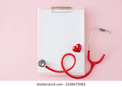 Сaring for the health idea. Top view arrangement of blank clipboard, stethoscope, red heart on pastel pink background with empty space for advert or text - Powered by Shutterstock