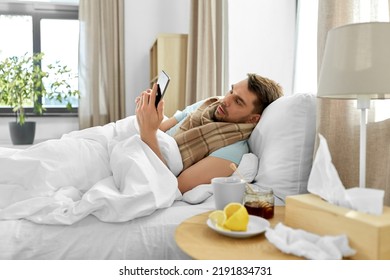 health, illness and people concept - sick man with smartphone in bed at home - Shutterstock ID 2191834731