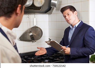 Health Inspector Meeting With Chef In Restaurant Kitchen