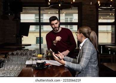 Health inspector sitting in a restaurant and writes a fine and a negative report to the owner or manager of the cafeteria after she finds poor hygiene conditions in the kitchen. Sanitary inspection  - Powered by Shutterstock