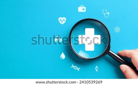 Health insurance concept with magnifying glass on blue background