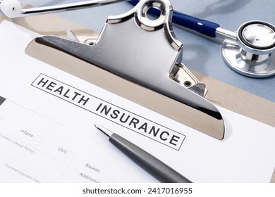 Health Insurance form and stethoscope on desk. No people - Powered by Shutterstock