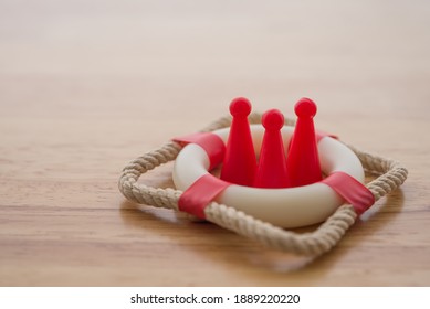 Health insurance or life insurance business and health care concept. People model in lifebuoy on wooden table background copy space. - Shutterstock ID 1889220220