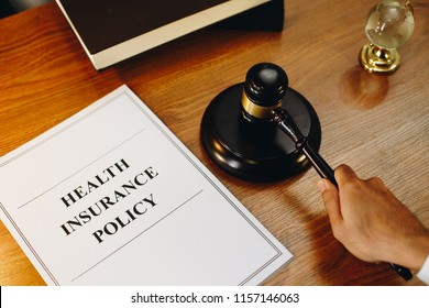 Health Insurance Policy Documents With Gavel At The Side