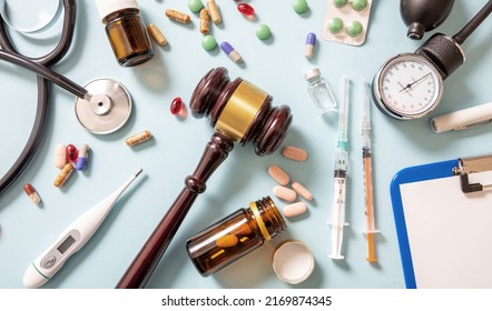 Health And Law Flat Lay. Judge Gavel, Medicine And Doctor Coat On Blue, Background, Top View. Medical Malpractice, Personal Injury Attorney.