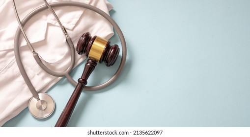 Health And Law. Medical Malpractice, Personal Injury Lawyer. Judge Gavel, Stethoscope And Doctor Coat, On Blue Background, Top View
