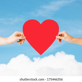 Health, Love And Relationships Concept - Closeup Of Couple Hands With Big Red Heart