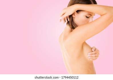 health, medicine and beauty concept - young woman checking breast for signs of cancer over pink background