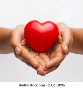 Health, Medicine And Charity Concept - Close Up Of African American Female Hands With Small Red Heart