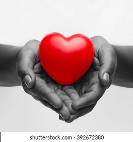 Health, Medicine And Charity Concept - Close Up Of African American Female Hands With Small Red Heart