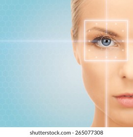 health, medicine, identity, vision and people concept - beautiful young woman with laser light lines on her eye over blue background - Shutterstock ID 265077308