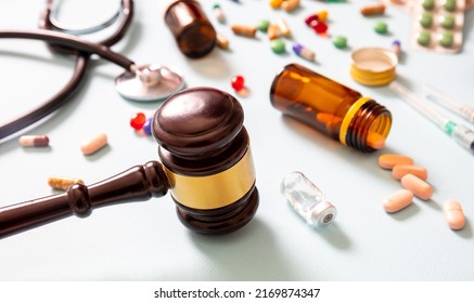 Health And Medicine Legal Issues. Medical Malpractice, Personal Injury Attorney. Judge Gavel And Medication On Blue Background, Close Up View