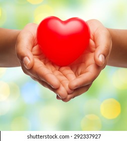 Health, Medicine, Love, Valentines Day And Charity Concept - Close Up Of African American Female Hands Holding Small Red Heart Over Green Lights Background