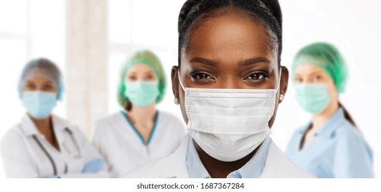 Health, Medicine And Pandemic Concept - Close Up Of African American Female Doctor Or Scientist In Protective Mask Over Medical Workers At Hospital On Background