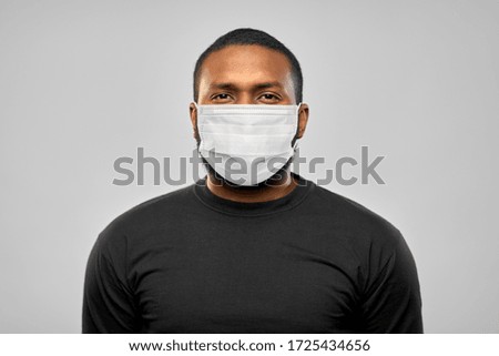health, pandemic and safety concept - african american young man wearing face protective medical mask for protection from virus disease over grey background